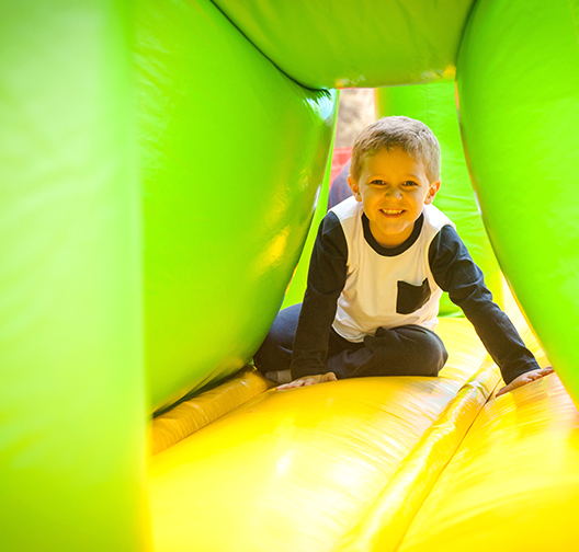 Child enjoys playing outside in blowup obstacle course